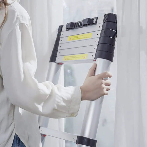 Person holding Telescoping Aluminum Ladder 10.5 Foot With One Button Retraction Collapsible Extension Ladder indoors