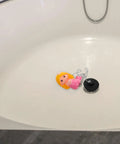 Mermaid Rubber Tub Stopper with Chain for Bathtub Drains lying in a white bathtub, featuring a colorful mermaid design.