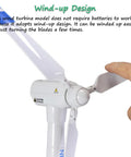 Close-up of a hand interacting with a Wind Turbine Toy Clockwork Generator Model STEM Science Kit For Kids And Makers.