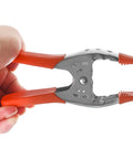 Hand holding a clamp from the Twenty Four Pack Of Heavy Duty Six Inch Spring Metal Clamps With 2.5 Inch Jaw Opening, Nickel Plated Steel For Carpentry.