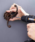 Using 20V Max Three-Eighths Inch Drill Driver With Power Share System to install a decorative coat hook on a wall.
