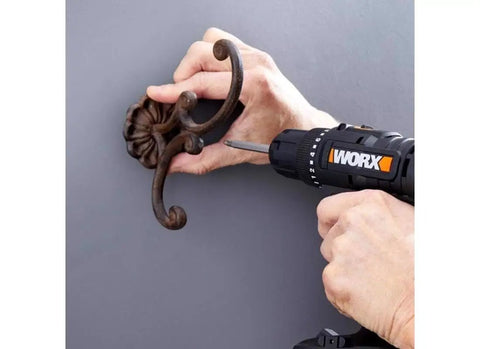 Using 20V Max Three-Eighths Inch Drill Driver With Power Share System to install a decorative coat hook on a wall.