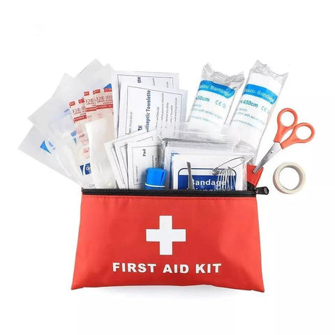 Red travel first aid kit pouch with white cross, opened to show bandages, scissors, tape, and wipes.