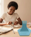 Woman using Zipper Jig Tool for Easy Zip Installation Handy Third Hand Slider Guide, blue plastic, at sewing table.