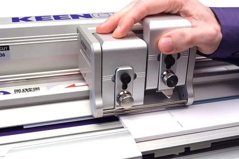 Hand operating the Evolution3 Bench Top Material Cutter With 64 Inch Cutting Length Self Adjusting Track Roller System