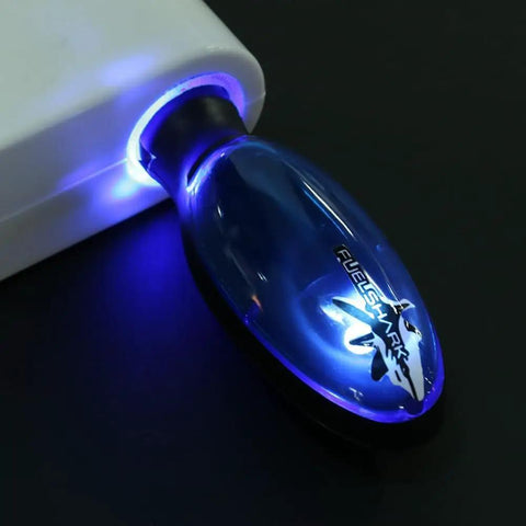 Close-up of Gas Saver Fuel Device Plug In Portable Spill Saver for cars cigarette lighter socket with blue glow