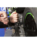 Motion Pro PBR Chain Tool installed on motorcycle chain; black aluminum tool with silver chain and green rim.