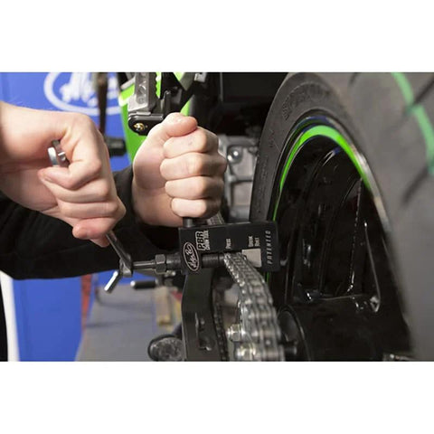 Motion Pro PBR Chain Tool installed on motorcycle chain; black aluminum tool with silver chain and green rim.