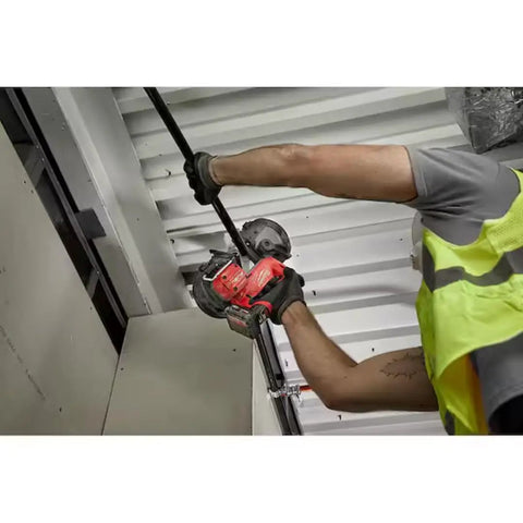 Worker using M12 Fuel Compact Cordless Band Saw With 2.5 Inch Throat Depth And 30.56 Inch Blade for cutting metal pipe overhead.