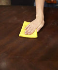 Person using Game Changer Pre Treated Wood Furniture Dusting Cloths Pack Of Five Lint Free Wipes on a wooden table.