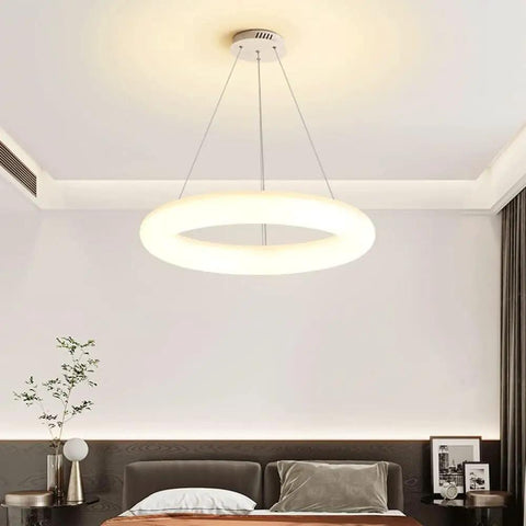 White Ring Acrylic LED Pendant Light for Bedroom, Modern Hanging Lamp, illuminating a contemporary bedroom ceiling.