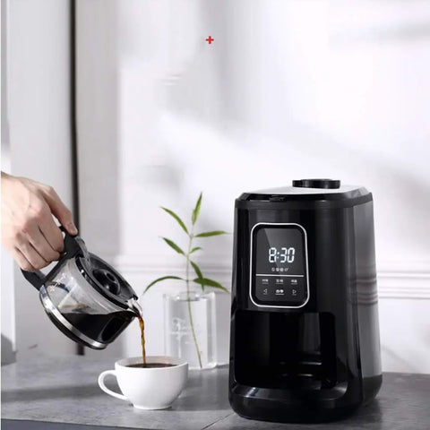 Compact Automatic Freshly Ground Coffee Brewer With Onboard Bean Grinder And Programmed Cup Settings pouring coffee into a white cup.
