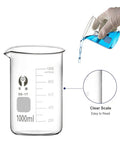 Glass Beaker Set for Lab Work 5 Piece Beaker Kit 1000ml with glove hand pouring blue liquid, clear scale visible