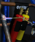 Oxypropane Welding Gas Cutting Torch Kit With Flint Lighter And Cylinder Holder Rack For Jewelers And HVAC Pros Pro Grade Brazing Soldering Map Gas Torch Set Heavy Duty Brass Fittings in use on a metal pipe.
