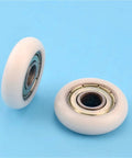 Two 5mm Pom Nylon Pulleys with circular arc design from 20pcs Circular Arc Plastic Coated 608ZZ Bearings on blue background.