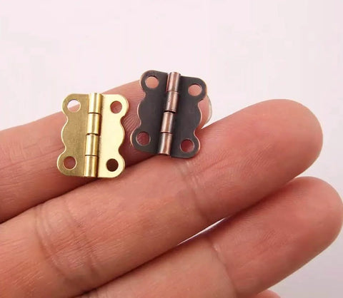 Close-up of Dope Retro Gold Butterfly Hinges Set 0.63 By 0.51 Inch Mini Box Hinges With Screws 10 Pack in hand