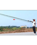 Heavy Duty 19.6ft Telescopic Cable Pulling Pole Made From High Density Carbon Fiber held by a person outdoors.