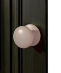 Front view of Two Pack XL White Bi Fold Closet Dummy Doorknobs With Wide Backplate on dark wood cabinet door.