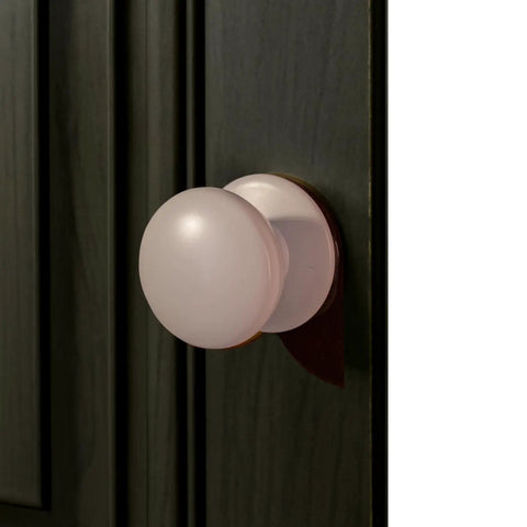 Front view of Two Pack XL White Bi Fold Closet Dummy Doorknobs With Wide Backplate on dark wood cabinet door.