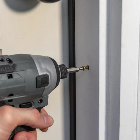 Top Shelf Exterior Trim Screws Nine By Three Inch Bronze Self Drilling Wood Fasteners Deck And Fence Toolkit Seventy Piece Heavy Duty Job Site Ready Hardware being driven into wood with a power drill.