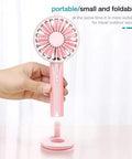 Hand holding a pink portable and foldable fan with zipper design, perfect for travel and outdoor sports.