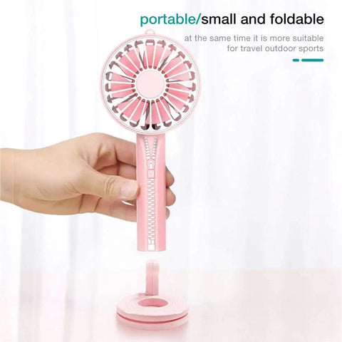 Hand holding a pink portable and foldable fan with zipper design, perfect for travel and outdoor sports.