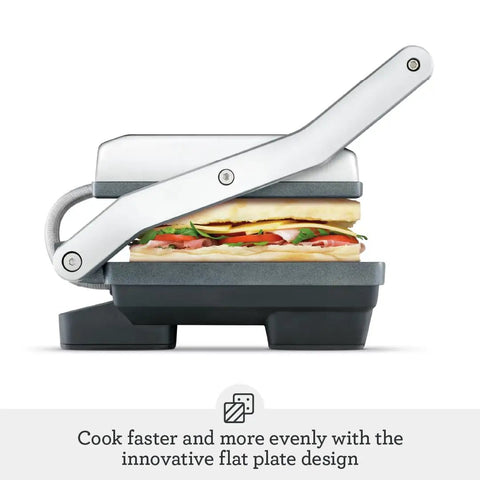 Brushed Stainless Steel Panini Maker With Dual Independent Heating Zones For Even Grilling And Toasting side view with sandwiches inside.
