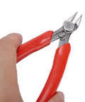 Close-up of a hand holding 107F1 Electronic Diagonal Pliers with high carbon steel cutting nippers and red ergonomic handle.