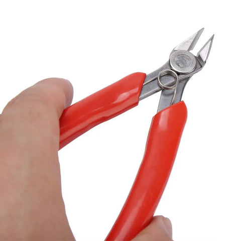 Close-up of a hand holding 107F1 Electronic Diagonal Pliers with high carbon steel cutting nippers and red ergonomic handle.