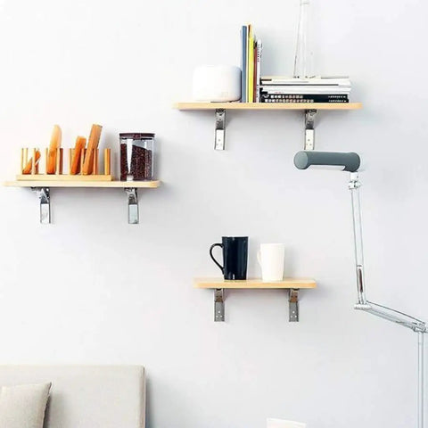 Heavy Duty Folding Triangle Brackets 4 Pack Wall Mounted Shelf Supports Sturdy Stainless Steel Space Saver with books and kitchen supplies.