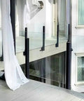 Top Tier Black Glass Railing Kit With Stainless Steel Deck Support, sleek black posts and glass panels on a modern balcony.