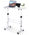 Standing Desk On Wheels Adjustable Height Sit Stand Desk Portable Rolling Laptop Desk White 16 By 31.5 Inches For Home Office Ergonomic Computer Table Height 27 To 43.5 Inches with laptop and plant on top.