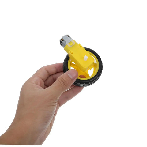 Electric Motor And Plastic Tire Wheel Set For RC Cars And Trucks held in hand, showing yellow motor and black tire
