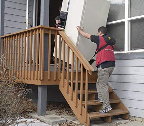 Side view: two workers use a padded Shoulder Dolly 3500 two-person lifting system to move a large appliance up outdoor stairs
