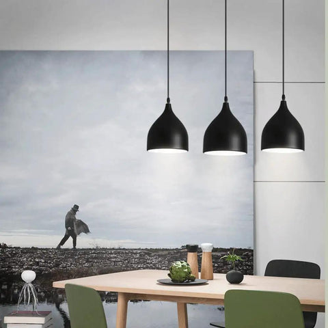 Dark Antique Farmhouse Pendant Light with Single Hanging Shade over a dining table, showcasing its rustic black design.