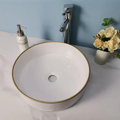 USZWBY Vessel Sinks Simple Hotel Bathroom Ceramic Sink Home Round Above Table Basin with gold rim and sleek faucet.