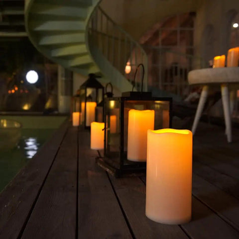 Weatherproof Outdoor Flameless LED Pillar Candles 4x8 Inches With Remote And Timer set on a wooden patio at night