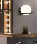 Solid Metal Wall Sconce With Glass Housing Delivers Hella Bright Ambient Glow Perfect For Indoor And Outdoor Decor, black finish mounted on wall.