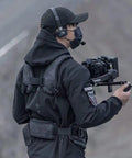 Person using lightweight gimbal support vest for long shoots with ergonomic comfort and expanded contact points secure dual handles.