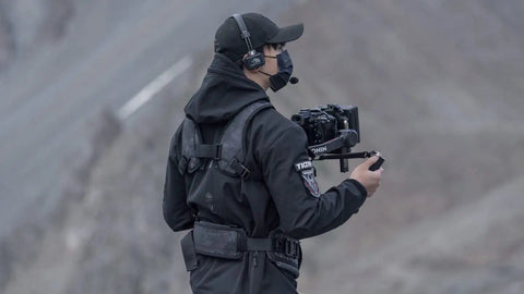 Person using lightweight gimbal support vest for long shoots with ergonomic comfort and expanded contact points secure dual handles.