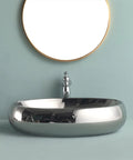 USZWBY Bathroom Vessel Sink European Ceramic Sink Art Basin Chrome Wash Basin Oval Sink Bathroom Sink Above Counter Basin with Faucet,Silver Bathro on a blue backdrop.