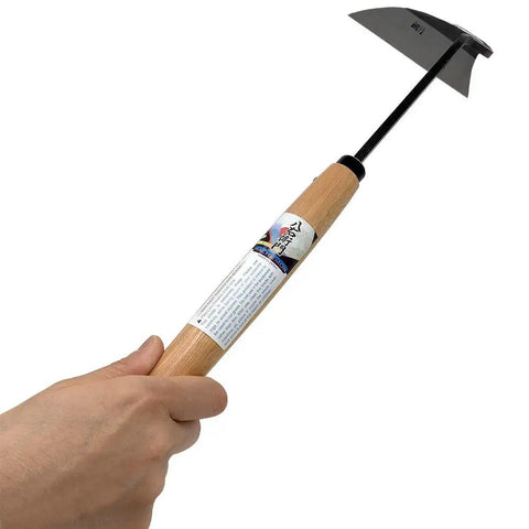 Beast Sharp Japanese Weeding Tool For Quick Easy Garden Weeding Long Nejiri Gama Hand Sickle in hand showing steel blade and wooden handle.