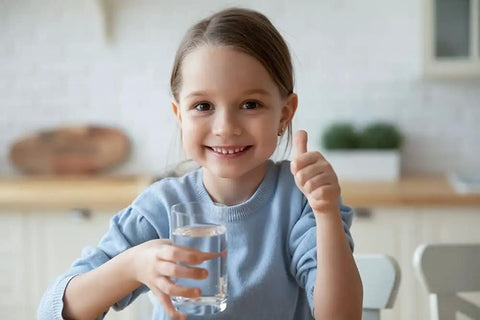 Child smiling, holding glass of water, symbolizing satisfaction with Stainless Steel Countertop Water Purifier Filter With 10 Micron Carbon Block