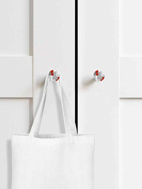 Top Shelf 2 Piece Cabinet Knobs Featuring Sleek Abstract Graffiti Prints In Bold Red And Charcoal Grey Solid Beech Wood Drawer Pulls For Kitchen Cupboard Doors Smooth To The Touch With Killer Durability And Pure Dope Style mounted on white cupboard, holding a tote bag.