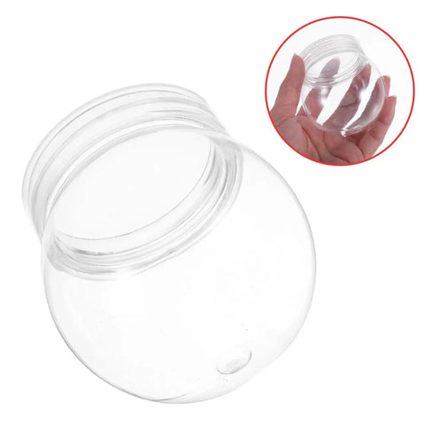 Close-up of a clear 4 inch snow globe kit with fillable plastic balls and screw cap, hand holding the globe for DIY decor and gift ideas.