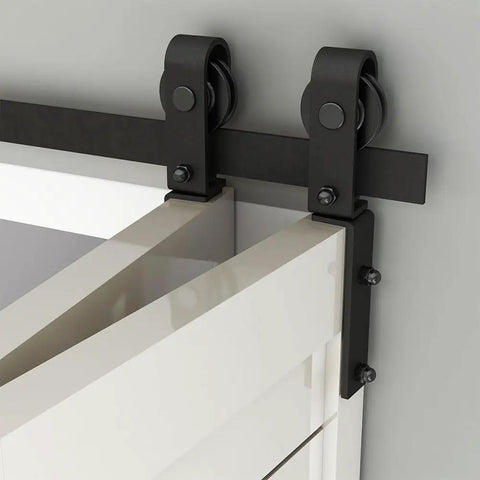 Close-up of bi-folding sliding barn door hardware track kit for two doors showing J shape track and rollers, doors not included