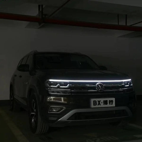 Car with 70 Inch White LED DRL Car Hood Light Strip With Dynamic Scan Start Up For Cars Trucks And SUVs in a garage.