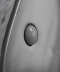 Close-up view of matte black oval vessel sink 23.5 by 15.7 inches, ceramic countertop bathroom basin with pop up drain detail.