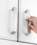 Hand installing 10 Pack 5 Inch Brushed Nickel Cabinet Pulls Satin Silver Cabinet Handles on white kitchen drawers