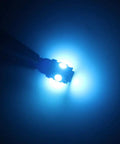 Lit Ice Blue 12V 194 W5W LED Bulb Replacement Kit glowing in the dark, showcasing bright 360° light for car interior lighting.